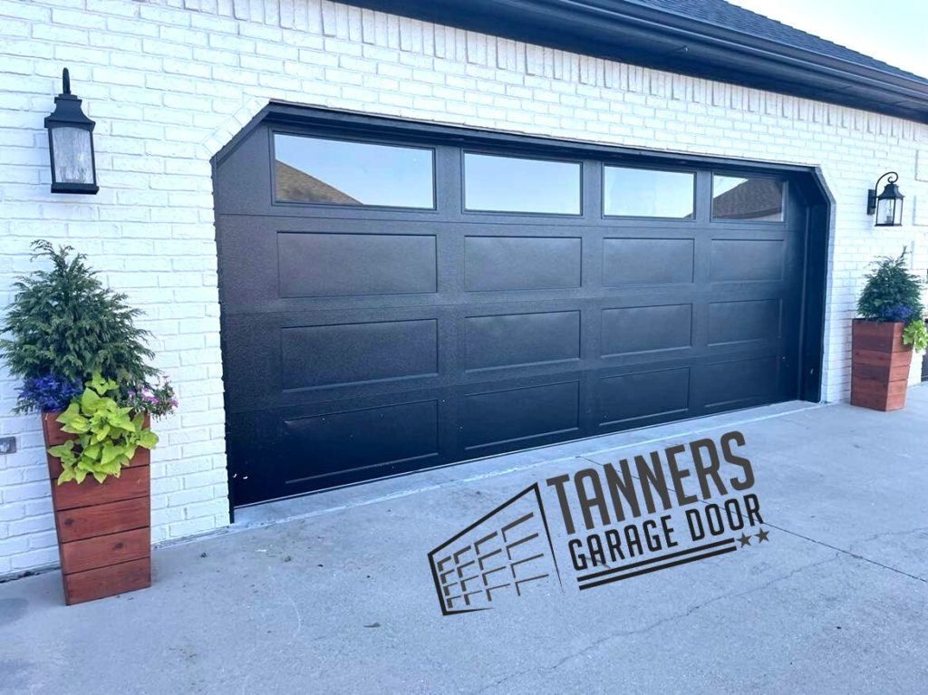 Black custom garage door with Tanners Garage Door logo